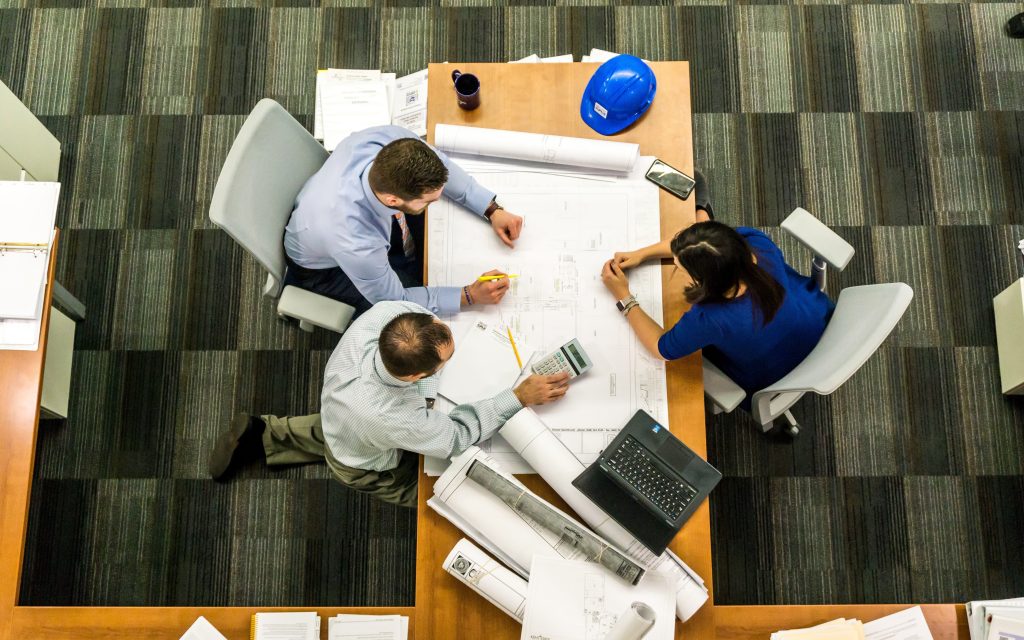 n equipo de profesionales colaborando en un entorno de oficina productivo y saludable, evidenciando el bienestar organizacional a través de la comunicación efectiva y el trabajo en equipo.