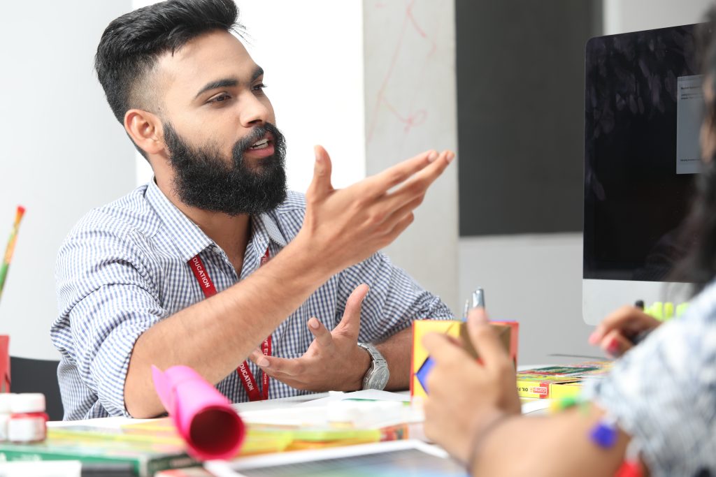 Un directivo aplica el liderazgo positivo mediante una escucha activa y feedback constructivo con un colaborador en una reunión de equipo colaborativa.